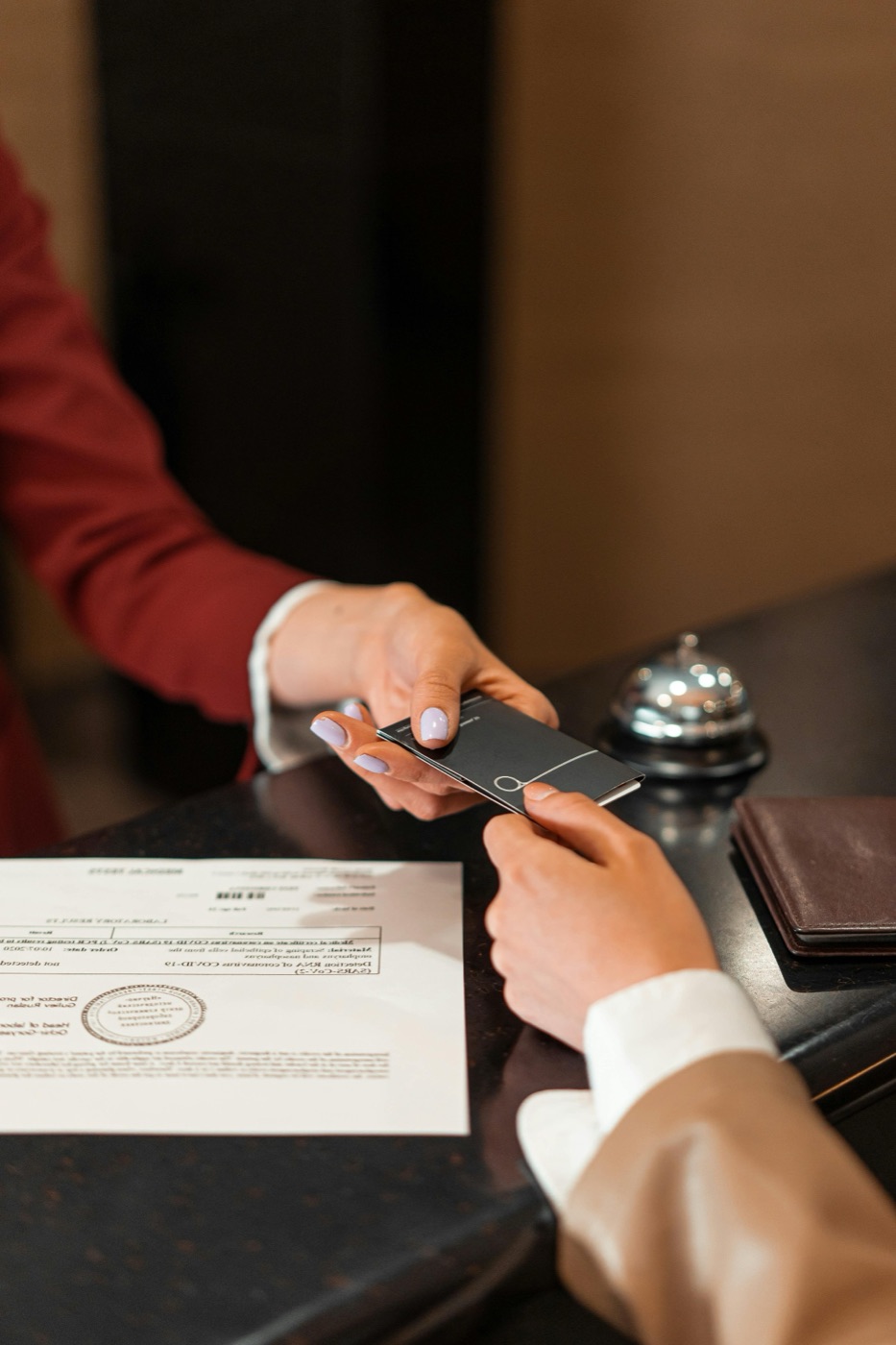 Hotel front desk handing a guest a room key